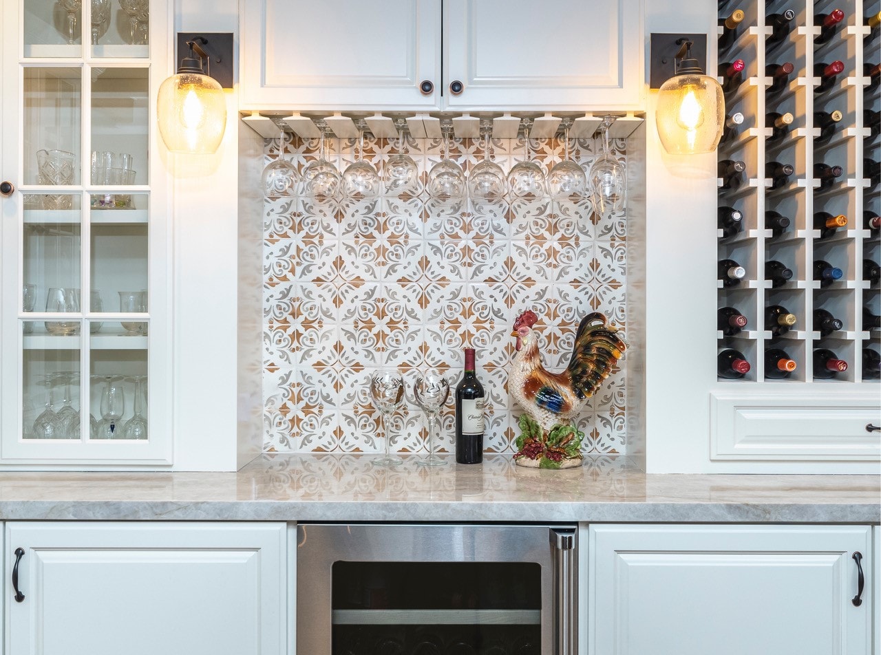 Built-in wine bar with ornate tile backsplash and hanging stemware — La Cañada