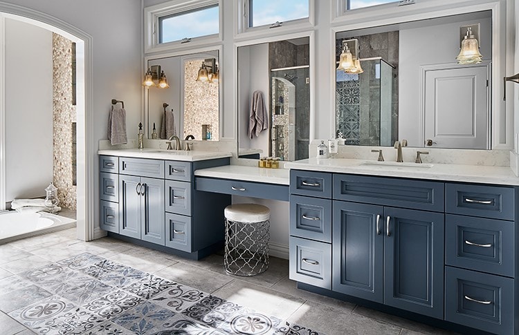 Master bathroom with dual navy vanity, marble counters and patterned tile floor — La Crescenta