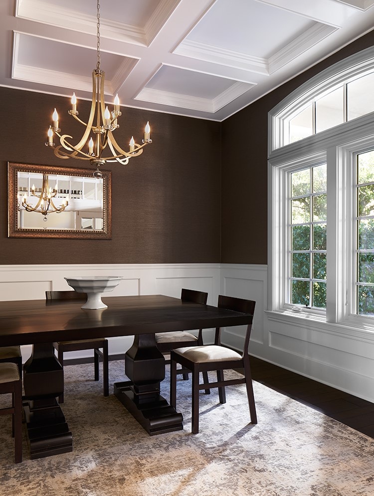 Formal dining room with dark walnut walls, coffered ceiling and brass chandelier — La Crescenta